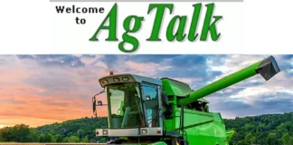 AgTalk image showing a green combine harvester in a harvested field at sunset with hills and trees in the background.