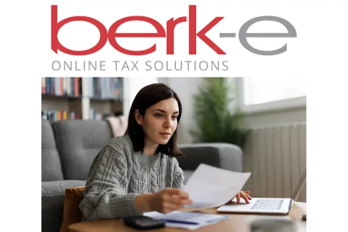 A woman reviews documents at home with a laptop under the Berk-e Online Tax Solutions logo, representing Berkheimer Tax services.