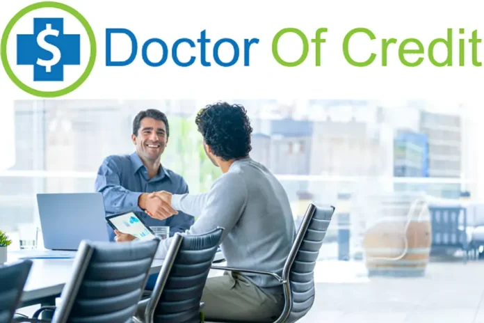 DoctorOfCredit handshake between two men in office meeting with laptop and tablet.