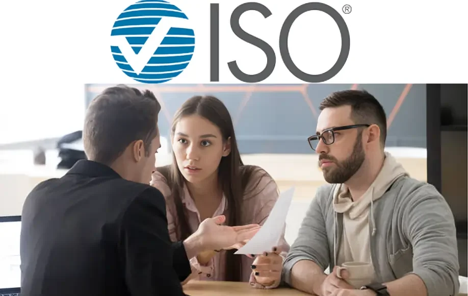 ISO ClaimSearch logo above three people sitting at a desk discussing paperwork in an office setting.