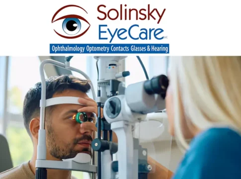 Solinsky EyeCare LLC eye exam with male patient undergoing vision test using diagnostic equipment by female optometrist.