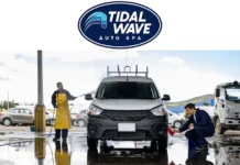 Tidal Wave Auto Spa workers washing a silver car with water hoses and cleaning tools at an outdoor car wash station.