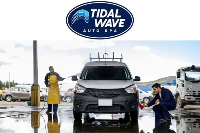 Tidal Wave Auto Spa workers washing a silver car with water hoses and cleaning tools at an outdoor car wash station.
