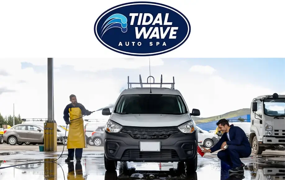 Tidal Wave Auto Spa workers washing a silver car with water hoses and cleaning tools at an outdoor car wash station.