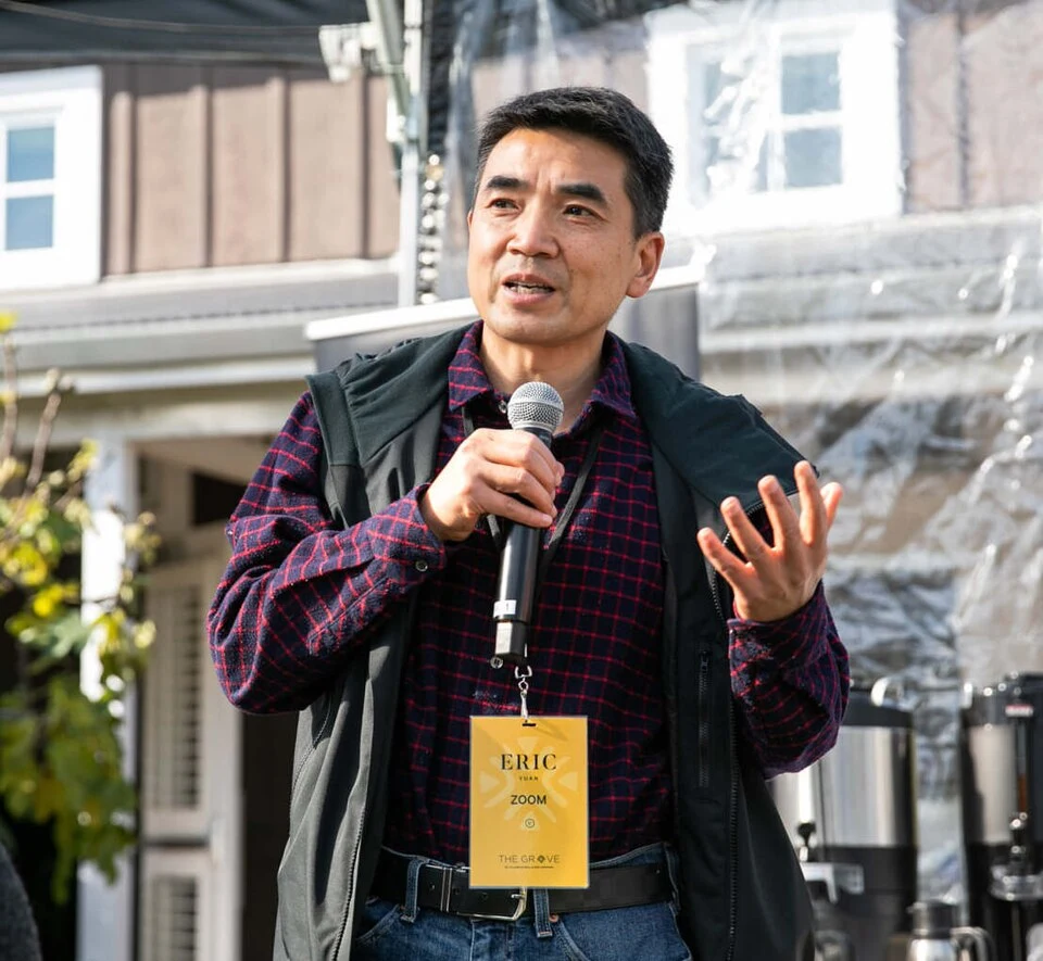 Zoom founder Eric Yuan speaking into a microphone at an outdoor event in 2021.