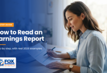 How to Read an Earnings Report: 7 Simple Steps A woman reviewing a printed quarterly financial report with a pen, with a bar chart on her laptop screen.