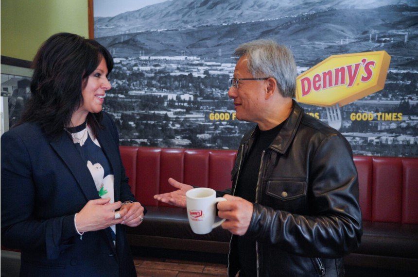 Nvidia CEO Jensen Huang, holding a Denny's coffee mug, talks with Denny's CEO Kelli Valade inside the Silicon Valley Denny's where Nvidia's founders planned the company in 1993.