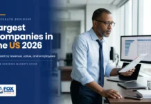 The Largest Companies in the US in 2026, Ranked Equity research analyst comparing a ranked company chart on his monitor with a printed report, illustrating the largest companies in the US