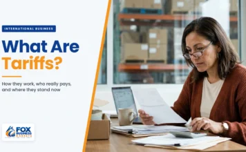 What Are Tariffs? How They Work, Who Pays, and Where They Stand Now What are tariffs explained: small business owner reviewing an import duty invoice with a calculator in her warehouse office
